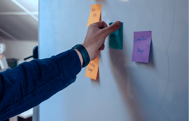 hand posting note on board